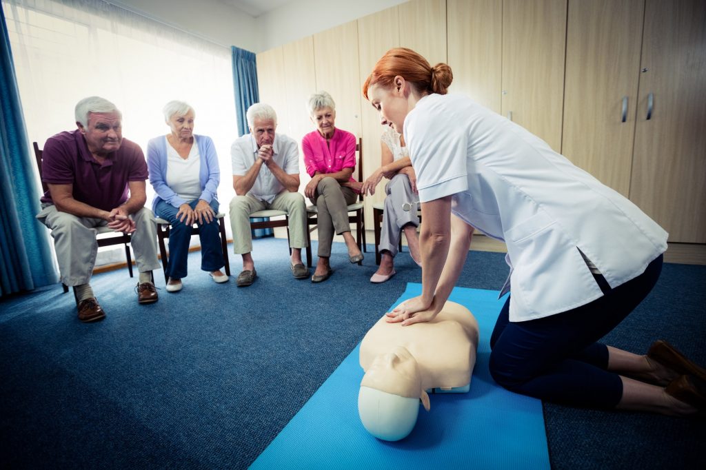 Nurse teaching first aid to a group of seniors